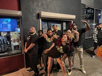 a group of people posing in front of a restaurant