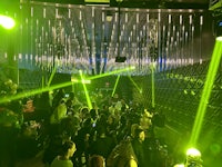 a crowd of people at a nightclub with green lights