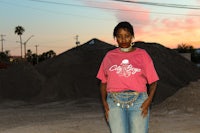 a woman standing in front of a pile of dirt